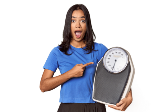 Filipino woman with scale in studio pointing to the side