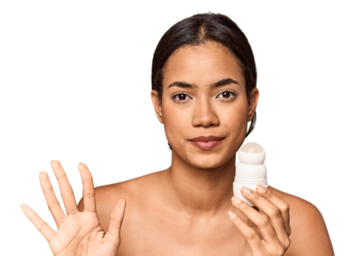 Filipino woman holds deodorant in studio smiling cheerful showing number five with fingers.