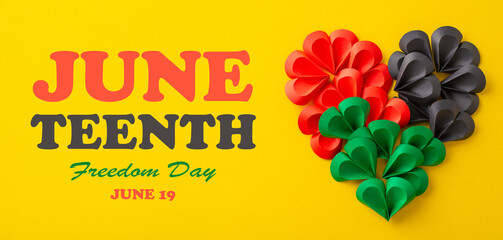 Vivid red, black, and green paper hearts creatively arranged on a bright yellow background,...