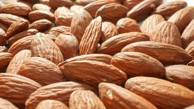 In a close-up, raw almonds stand proud with their textured, earthy brown shells. Each detail highlights the natural goodness and health benefits of this beloved snack.