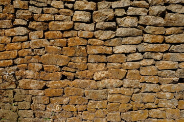 natural stone wall. box-shaped natural stone stacked into a natural stone wall. limestone, andesite, marble is often used for natural stone walls. this stones is a good architectural element.