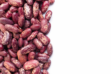Uncooked, variegated kidney bean seeds border on white background. Copy space for text. Top view