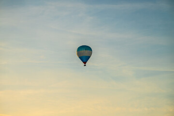 Blue white and red hot air balloon in evening sun.