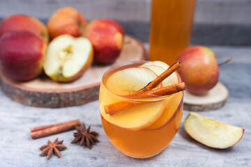 Hot mulled apple cider, juice with cinnamon and anise on wooden background.   