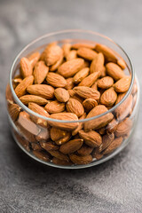 Peeled almond nuts in jar on kitchen table.