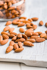 Peeled almond nuts on kitchen table.