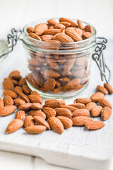 Peeled almond nuts in jar on kitchen table.