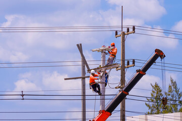 Electricians team with crane truck are working to install electrical equipment on new electric...