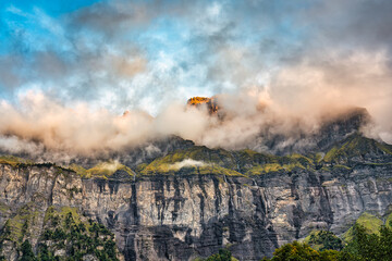 Giffre valley of mountain range with cascade and foggy in the evening at Sixt Fer a Cheval, French Alps, France