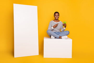 Full body photo of young girl indicate finger mobile promo recommend app sit platform isolated over...