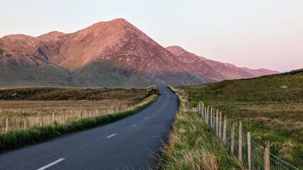 Empty scenic road trough nature and mountains at sunset, Inagh valley, Connemara, Galway, Ireland,...