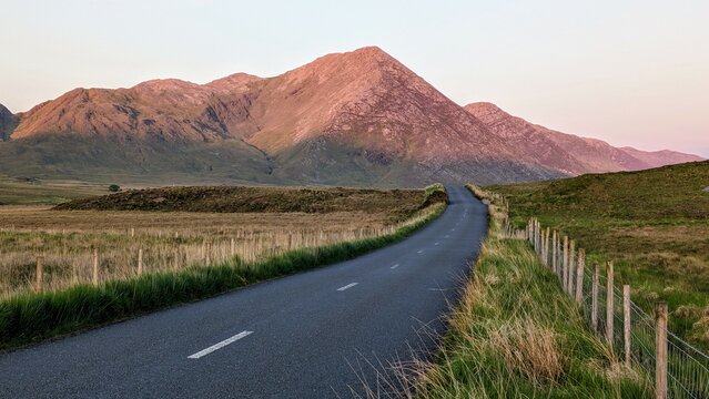 Empty scenic road trough nature and mountains at sunset, Inagh valley, Connemara, Galway, Ireland, landscape background, wallpaper