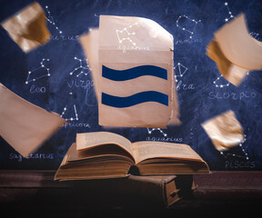 Zodiac sign Aquarius  on old paper flying above old astrology books.