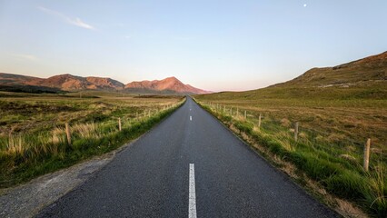 Empty scenic road trough nature and mountains at sunset, Inagh valley, Connemara, Galway, Ireland, landscape background, wallpaper