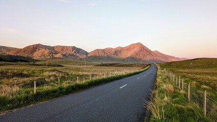 Empty scenic road trough nature and mountains at sunset, Inagh valley, Connemara, Galway, Ireland,...
