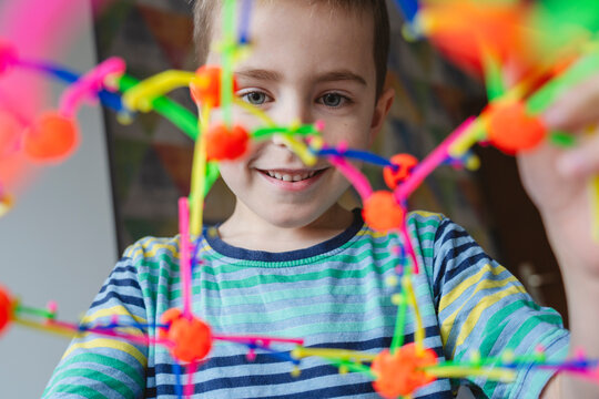 Smiling boy playing with expandable breathing ball at home