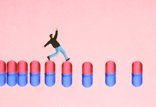 Man stumbling over medical capsules against pink background