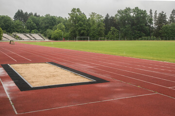 Long jump sand pit and track and field lines in stadium