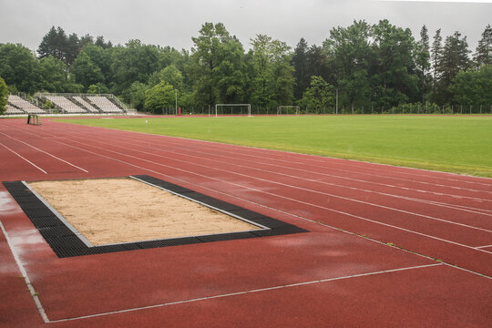 Long jump sand pit and track and field lines in stadium - Powered by Adobe