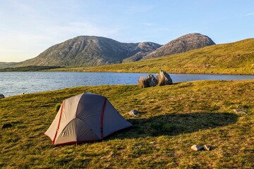 Camping tent by Lough Inagh, Connemara national park, county Galway, Ireland, lakeside landscape scenery with mountains in background, scenic nature wallpaper © Hq Visual Studio
