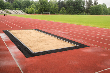 Long jump sand pit and track and field lines in stadium