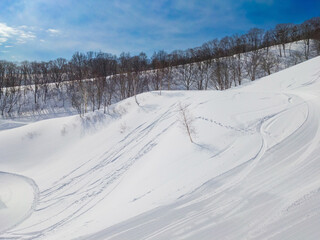 Fresh snow slopes viewed from a chairlift on a sunny day (Madarao Kogen, Nagano, Japan)