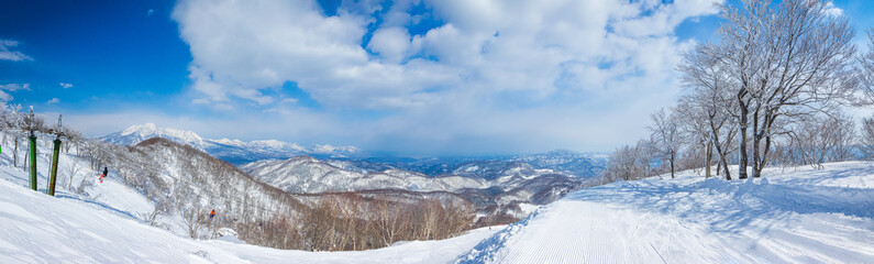 Panorama view of snow slopes from the summit on a sunny day (Madarao Kogen, Nagano, Japan)