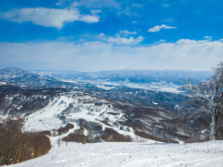 Snow resort viewed from the top of a steep slope a sunny day (Madarao Kogen, Nagano, Japan)