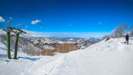 View of snow slopes and peaks a sunny day (Madarao Kogen, Nagano, Japan)