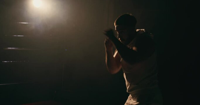 A man trains in a boxing club, a fight with a shadow.