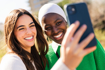 two young female friends smiling happy and having fun taking selfie photo with mobile phone,...
