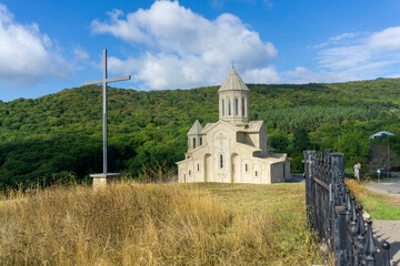 Saint Ekvtime church of Kiketi village, iron fence and high iron cross. Mountain on background