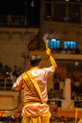 Ganga aarti, Portrait of young priest performing holy river ganges evening aarti at dashashwamedh ghat in traditional dress with hindu rituals.