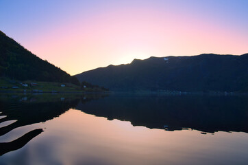 Norwegian fjord landscape at dusk. View of mountains with rough vegetation.