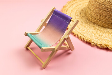 Colorful beach chair, straw hat on pink background. Summer, holidays and beach concept. Creative...