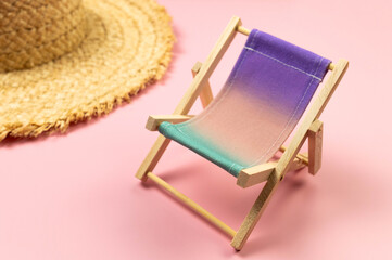 Colorful beach chair, straw hat on pink background. Summer, holidays and beach concept. Creative...