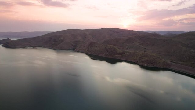 Aerial view of Langisfor Lake at sunset with majestic mountain peaks, Lake Argyle, Queensland, Australia.