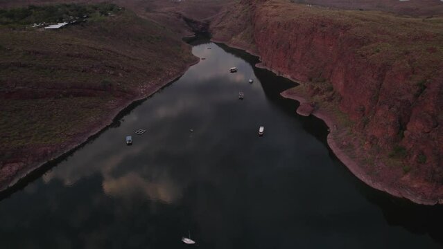 Aerial view of serene Lake Argyle at sunset with majestic mountains and tranquil water, Queensland, Australia.