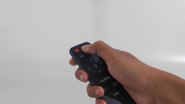 male hand gesture holding and pressing buttons on tv and audio remote control isolated on white background