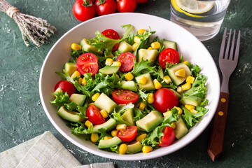 Salad with avocado, tomatoes and corn. Healthy eating. Vegetarian food.
