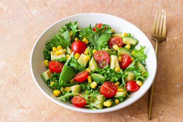 Salad with avocado, tomatoes and corn. Healthy eating. Vegetarian food.
