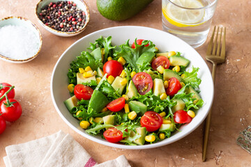 Salad with avocado, tomatoes and corn. Healthy eating. Vegetarian food.