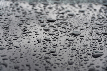 Macro shot of raindrops on a metal surface. Ideal for creating unique patterns and backgrounds, showcasing the intricate details and texture of water droplets