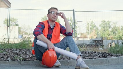 Exhausted construction superintendent resting during work break on site