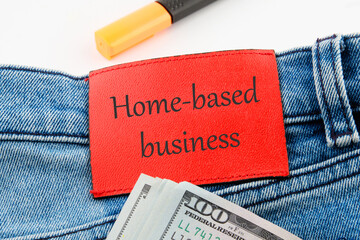 Text Home based business on the leather insert of jeans with dollar bills sticking out
