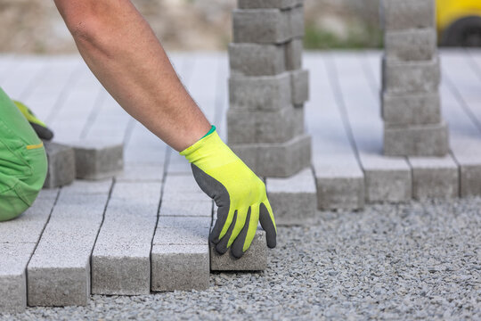 Process of building sidewalk, worker laying interlocking walking path, industrial concept