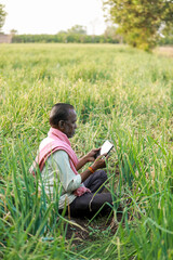 Indian farm worker holding tablet