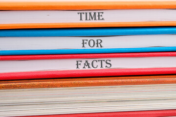 Time for facts message written on notebooks stacked in a pile