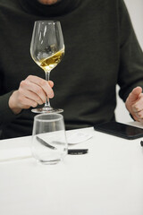 Sommelier Analyzing White Wine Clarity Swirling it, Vertical Close Up 