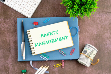 SAFETY MANAGEMENT text on a blank sheet of a notebook. View from above